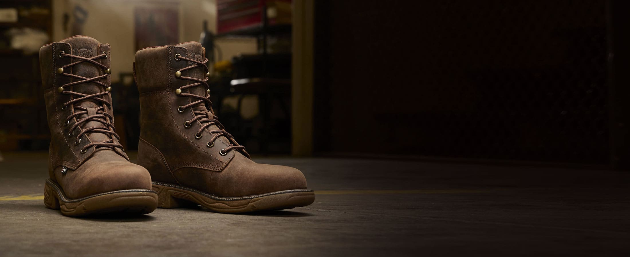 Men’s Rush 8” Lace Up Nano Comp Toe work boot in brown posed in a work space on concrete.