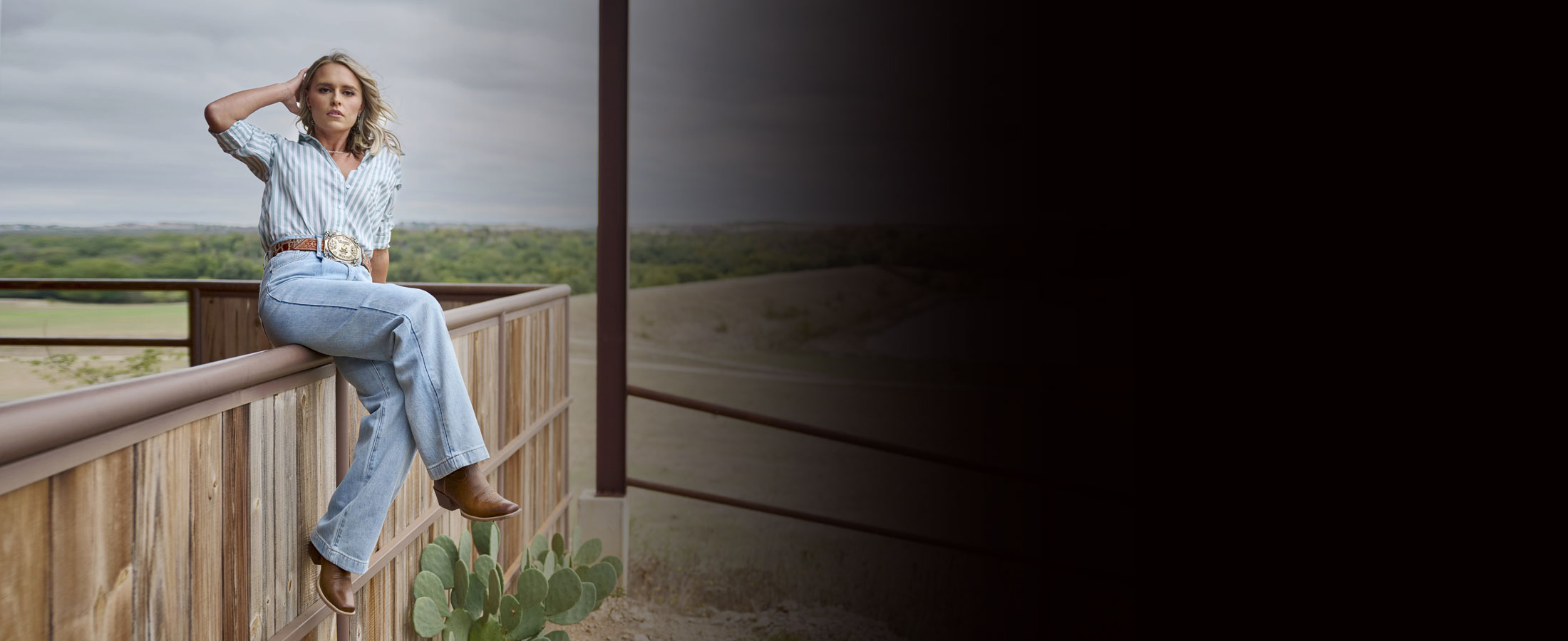 A woman wearing Justin Gypsy Western boots while sitting on a fence.