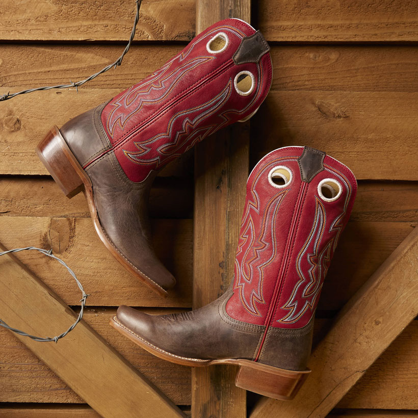 Ante Up 13” Western boot in brown, hung by barbed wire on wood.