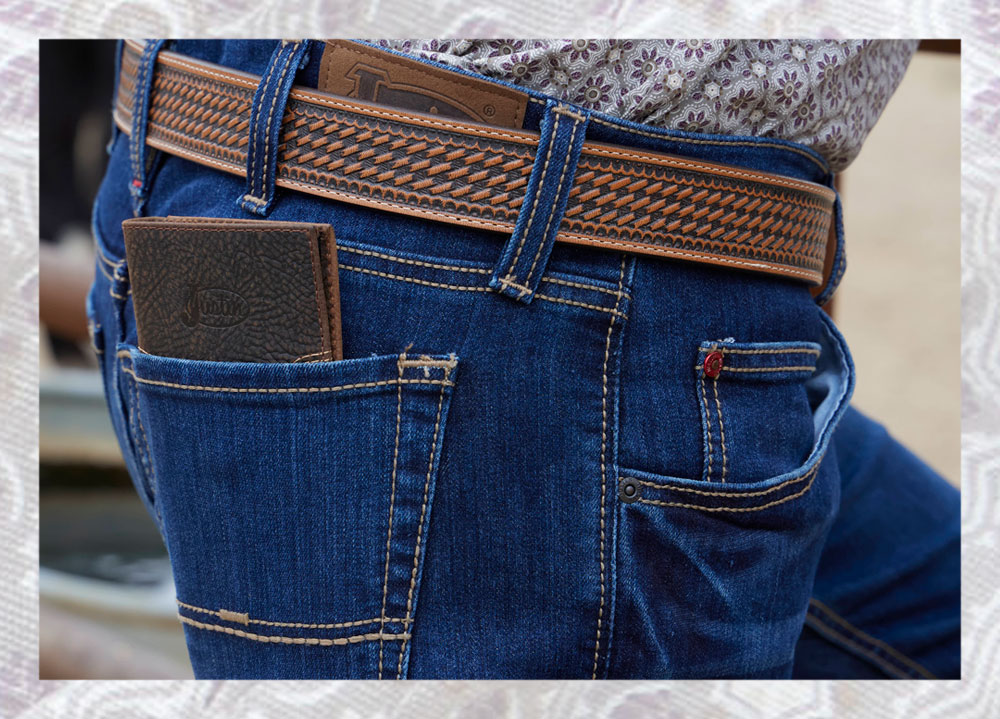 Un primer plano de un hombre vestido con Justin Jeans y una billetera Justin marrón en el bolsillo trasero.