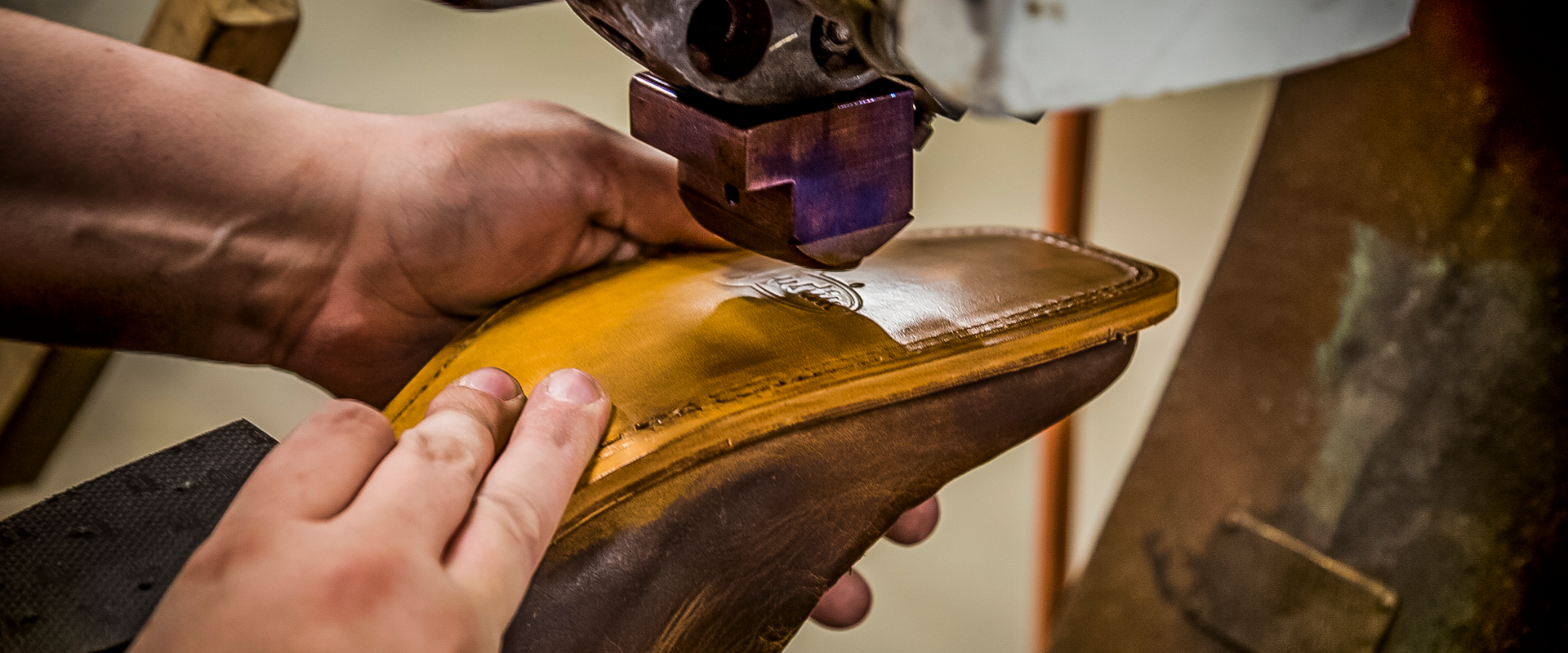 Man uses machine on sole of Justin boot