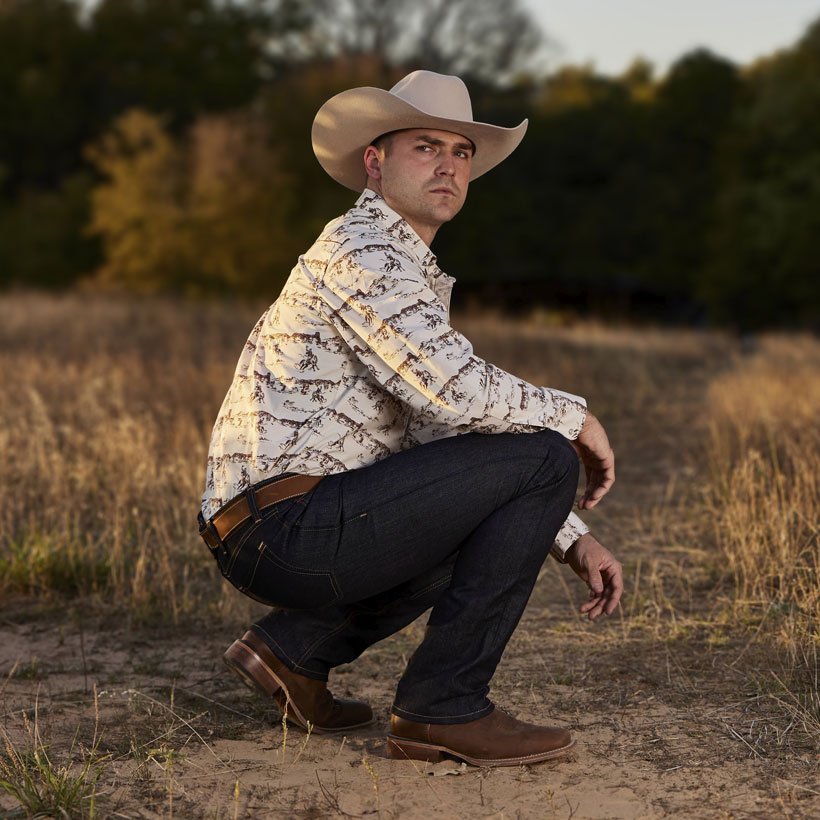 Classic Straight Leg Mens Jeans worn by a man in a cowboy hat kneeling down and posing in a field.