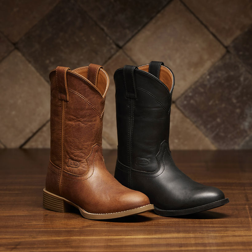 A brown women’s roper boot and a black women’s roper boot in front of a stone background.