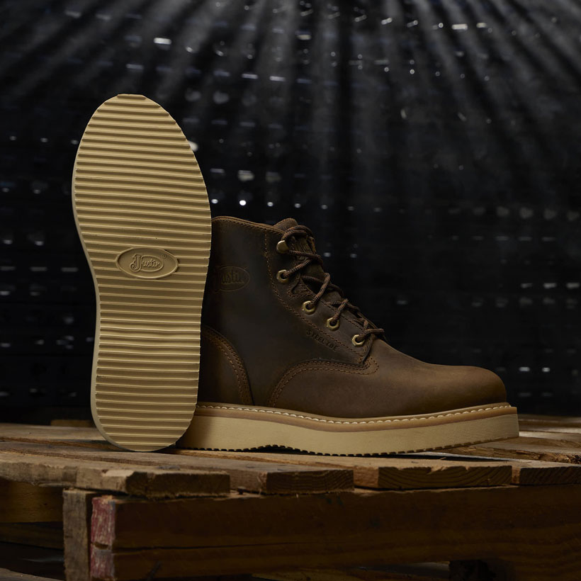 Maxwell 6" Lace Up work boot posed on a wood pallet in a dark room. 