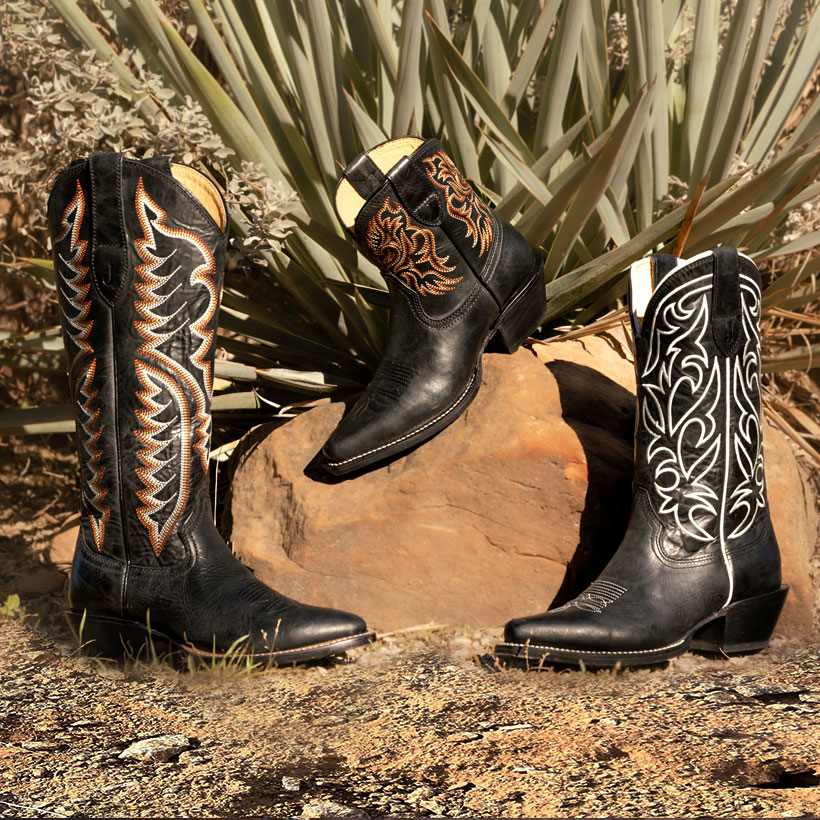 Bota vaquera Evelyn de 15” para mujer en color negro, bota vaquera Josephine de 12” en color negro y bota Isabella de 7” en color negro, posando junto a un cactus verde y sentada sobre una roca.