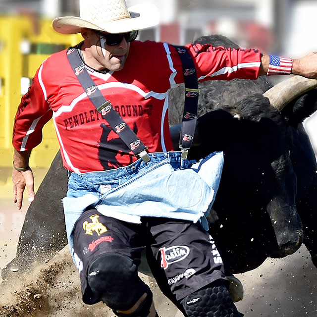 Dusty Tuckness wearing a red shirt and stepping in front of a bull.