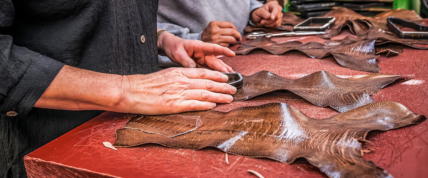 Worker placing a cutting die on an exotic leather.