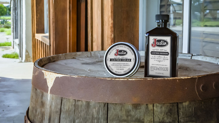 Justin leather care products sitting on a barrel.