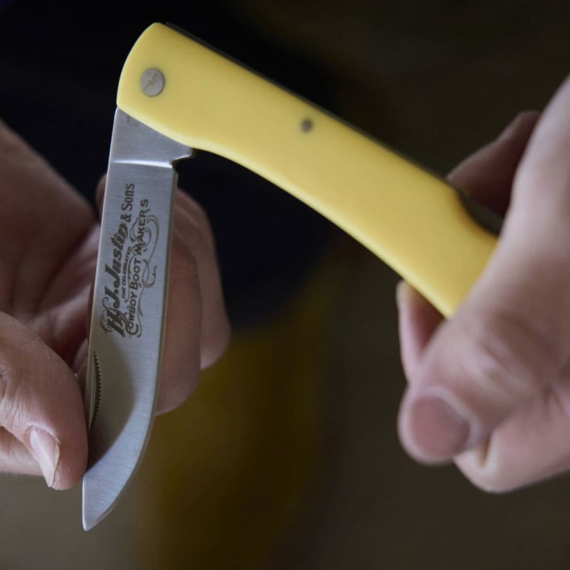 Men’s Rangebuster pocket Knife in yellow held by a man folding the knife closed.