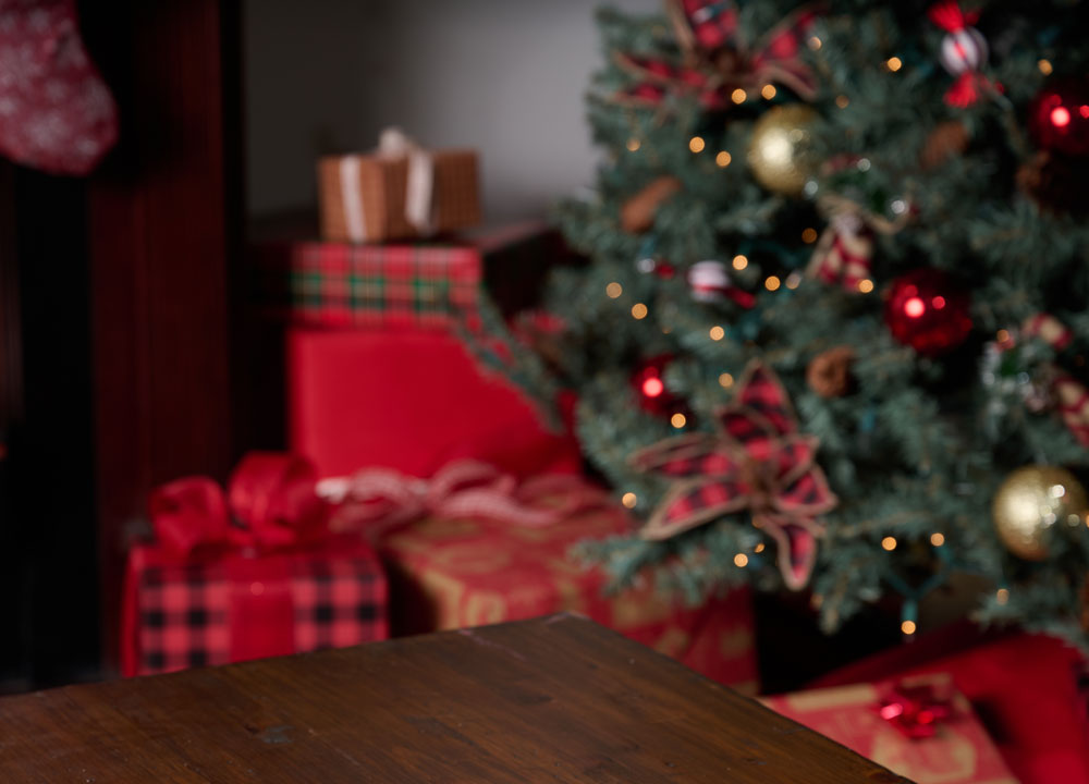 Christmas scene with red christmas presents wrapped under a tree.