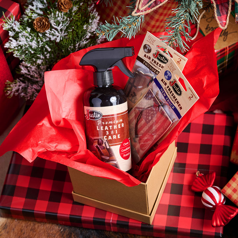 Premium Leather 3-In-1 cleaner in a box with two air fresheners in the scents New Truck and Thunder under a Christmas tree.