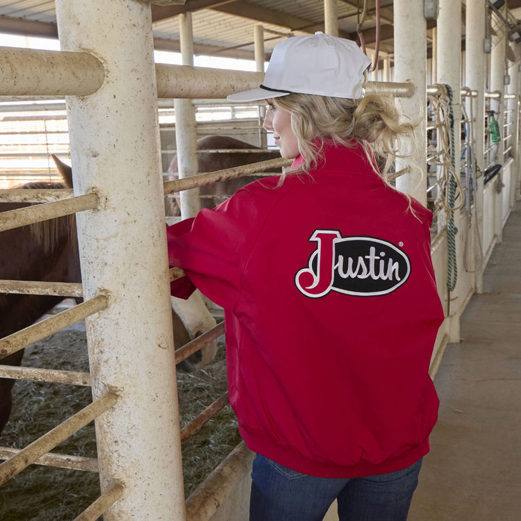 A woman wearing a Justin Logo Bomber Jacket in Red. Shop Justin Bomber Jacket.