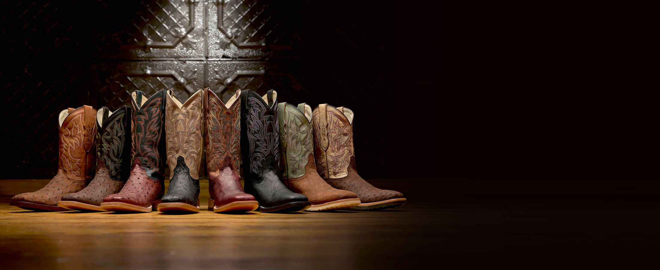 Three Bars Smooth Ostrich western boot in black, Three Bars Smooth Ostrich western boot in Brown, Doc bar Full Quill Ostrich western boot in brown, Doc bar Full Quill Ostrich western boot in black, King Full Quill Ostrich western boot in Brown posed against a black wall.