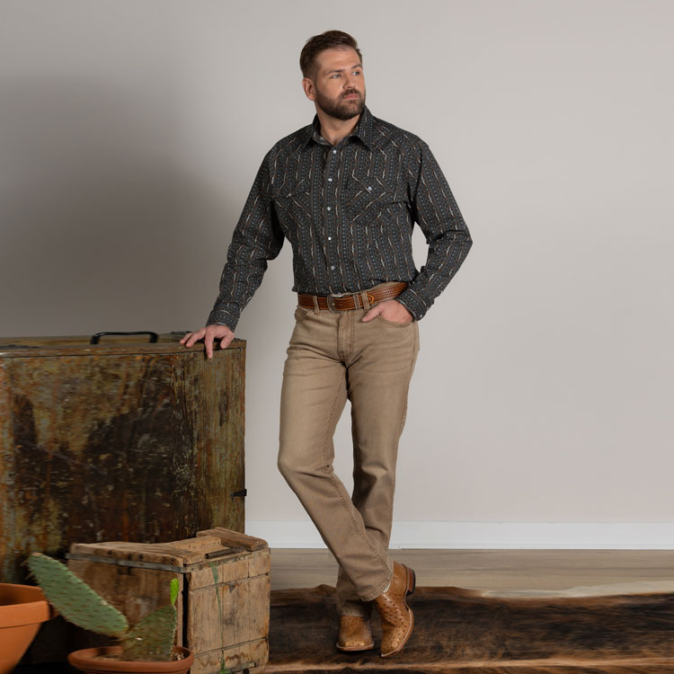 A man wearing HJ Justin & Son Snap Shirt in Black Stripe Print, the Original Straight Leg Men's Jeans in Sand Dune and  exotic leather cowboy boots. Shop Hj Justin & Son Snap Shirts.