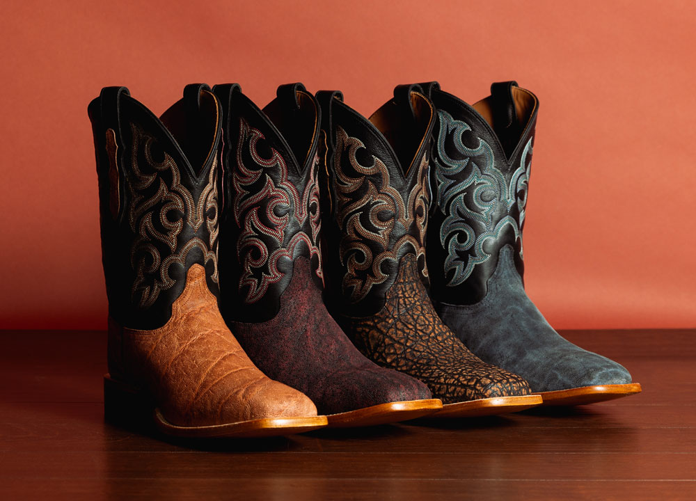 Pards Elephant western boots in Brown, Pards Elephant western boots in red, Pards Elephant western boots in tan, and Pards Elephant western boots in black, posed in front of an orange wall.