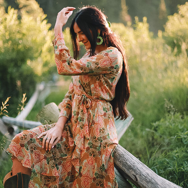 A woman wearing the Justin Women's Wrap Maxi Dress in tan.