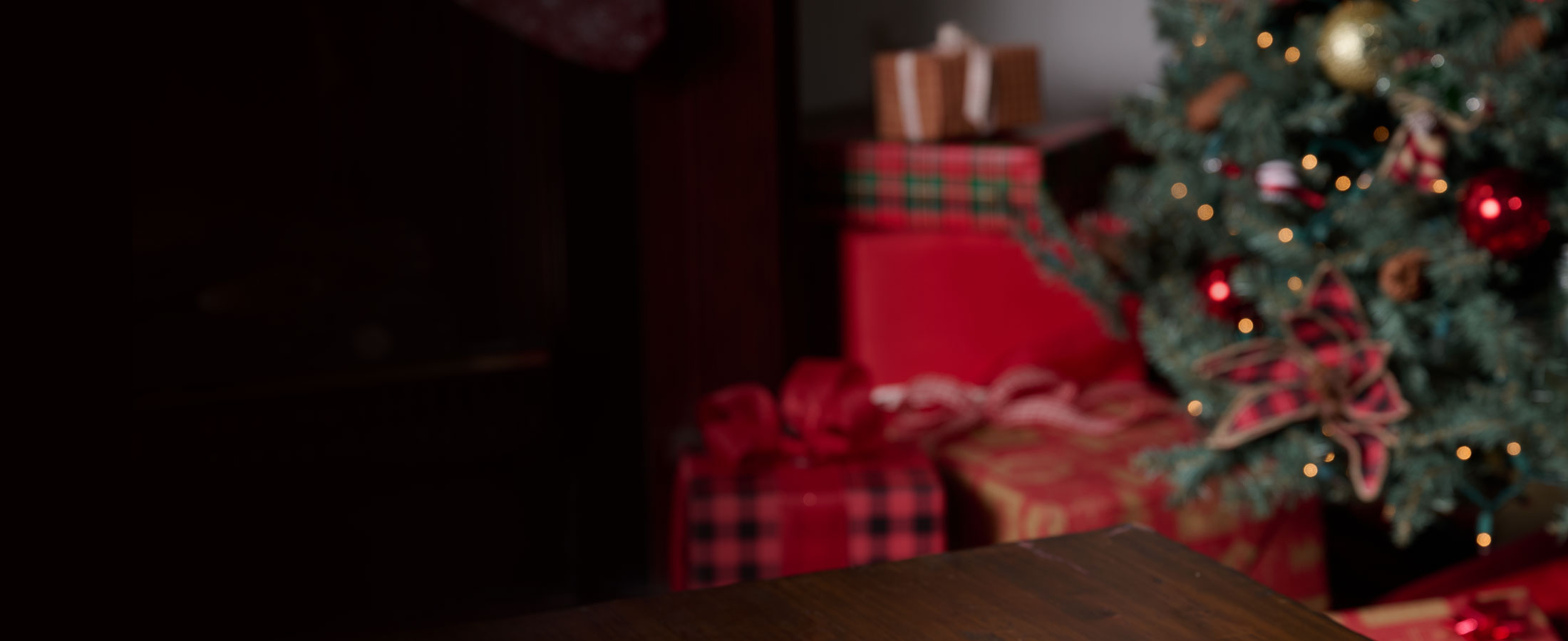 Christmas scene with red christmas presents wrapped under a tree.