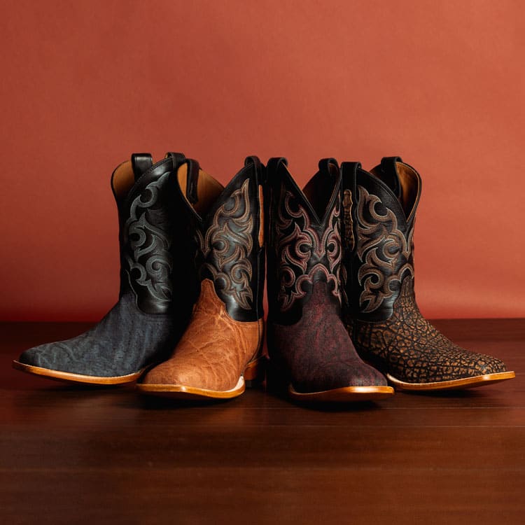 Men’s Pards elephant cowboy boots in brown, Men’s Pards elephant cowboy boots in  red, and Men’s Pards elephant cowboy boots in blue, posed on a table.