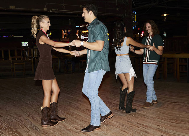 Two couples dancing on a dance floor at Billy Bob’s Texas/ They are all wearing Justin boots.