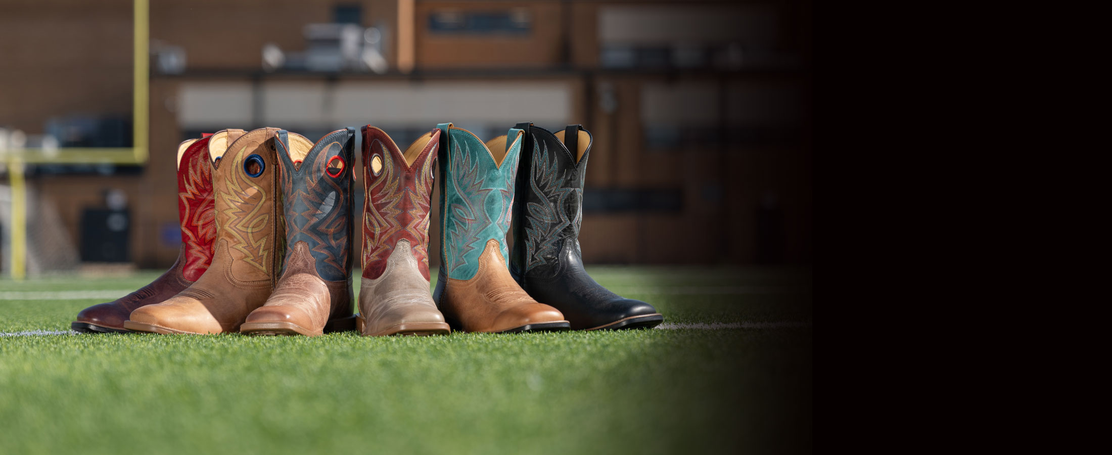 A group of Justin Untamed western boots displayed on a turf field.