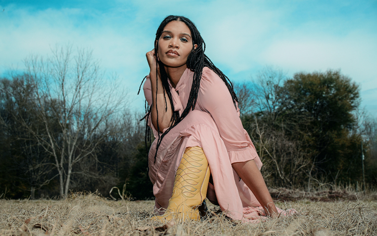 Cadance en el campo con vestido rosa y botas amarillas.