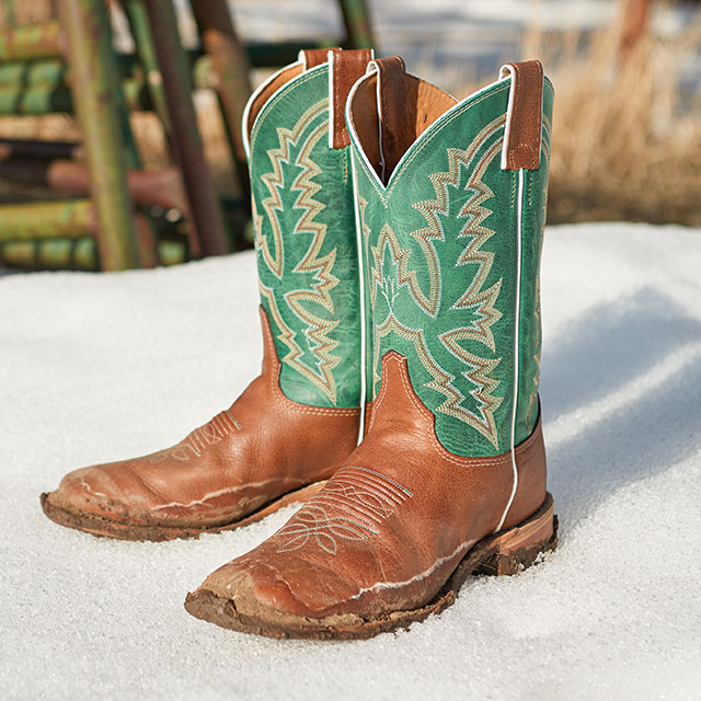 The Justin Kenedy 11-inch Western Boots in green and brown in the snow. Shop Kenedy.