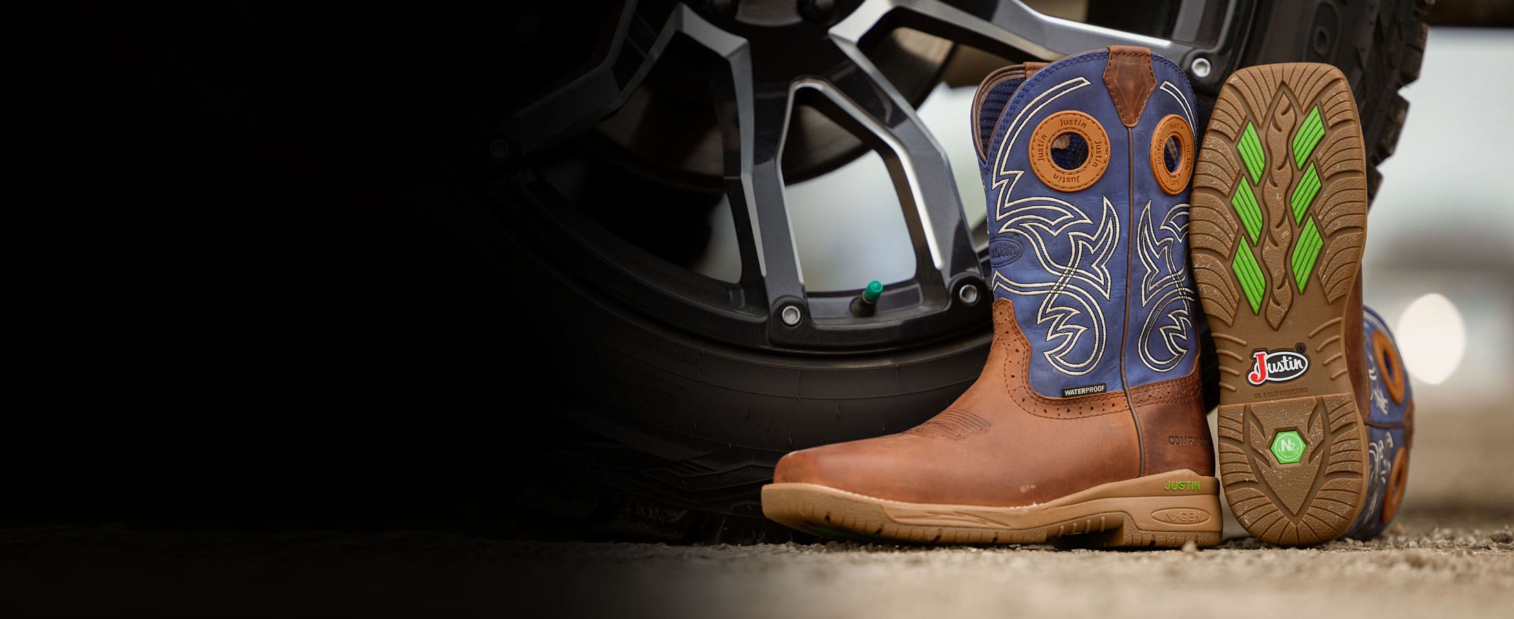 Men’s NiTread 11” Waterproof Nano Comp Toe work boot in brown and blue posed next to a truck tire.