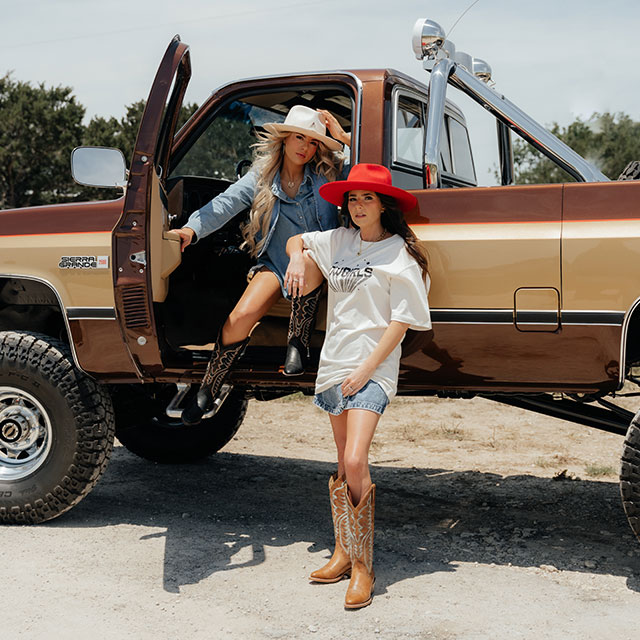 Evelyn 15" Western in black and brown being worn and posed by two women near a pickup truck.