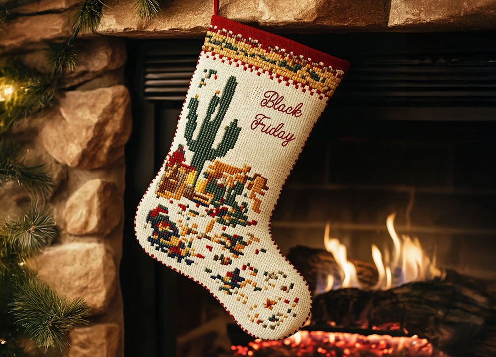 A cozy fireplace scene with greenery and a white stocking with a cactus on it that reads "Black Friday."