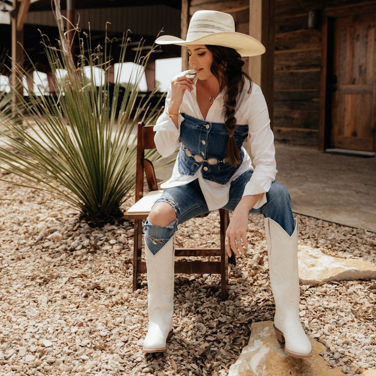 A woman wearing Justin Evelyn 15-inch Western boots in white. Shop Evelyn