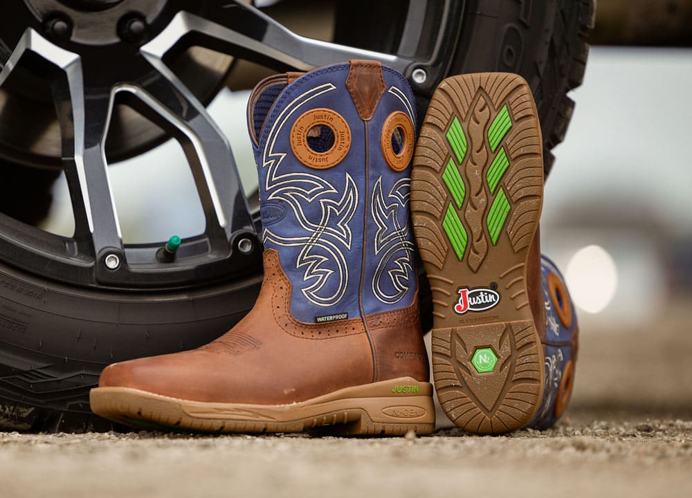 Men’s NiTread 11” Waterproof Nano Comp Toe work boot in brown and blue posed next to a truck tire.